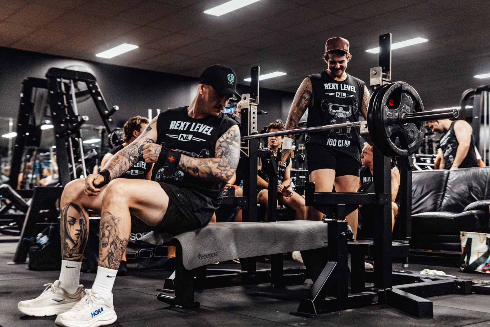 Members spotting a heavy bench press at the 100 Club