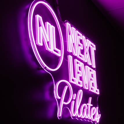 Next Level Reformer Pilates studio pink neon sign